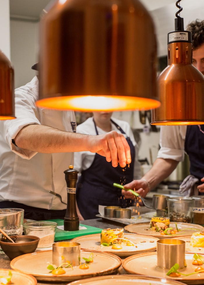 Chef plating a dish in a restaurant kitchen